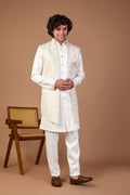 Man wearing a traditional white sherwani with a brown background